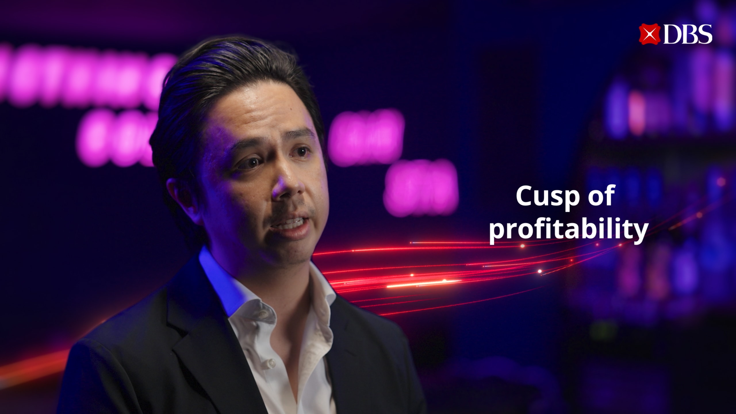 A person in a suit with neon text, "Cusp of profitability."